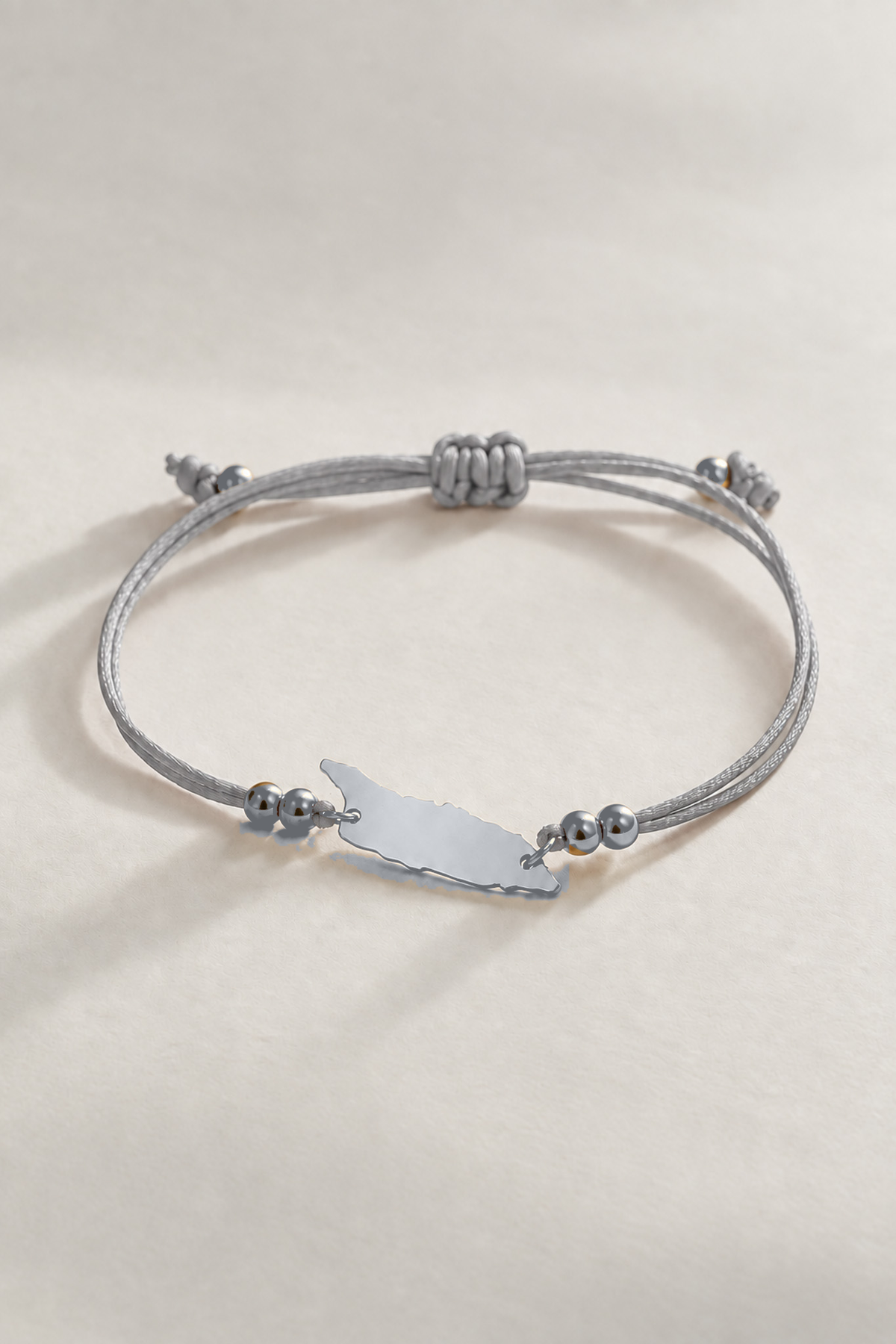Silver-tone Aruba island charm on silver gray cord bracelet