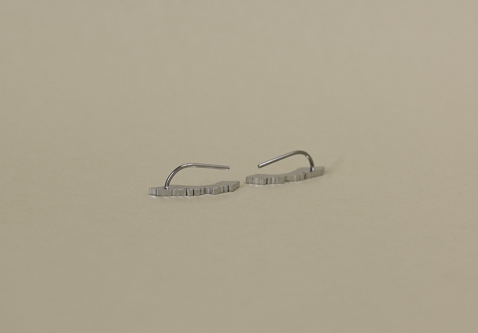 Silver Curaçao ear climber earrings displayed flat