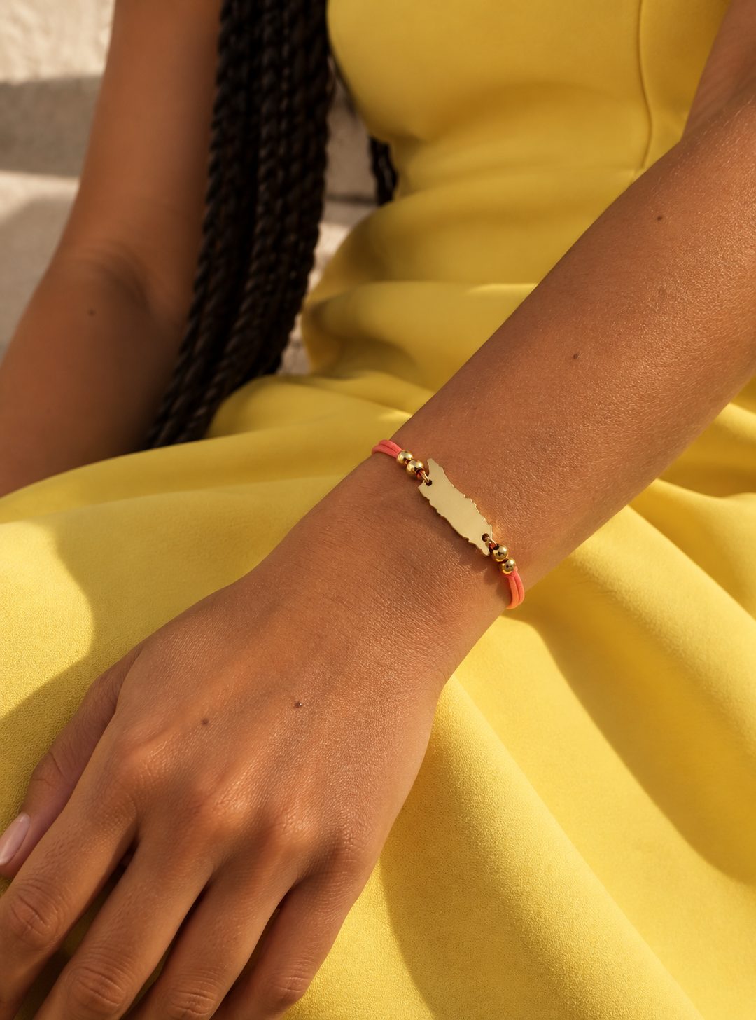 A close-up of a person's wrist wearing a Aruba bracelet. 