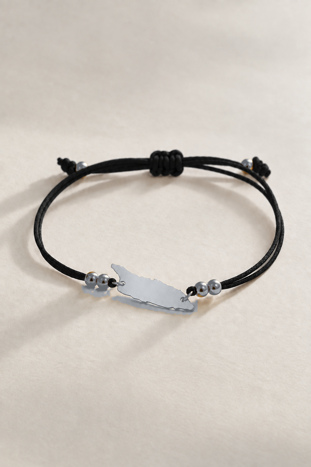 Silver-tone Aruba island charm on black cord bracelet