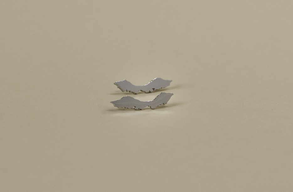 Front view of silver Curaçao island-shaped ear climber earrings