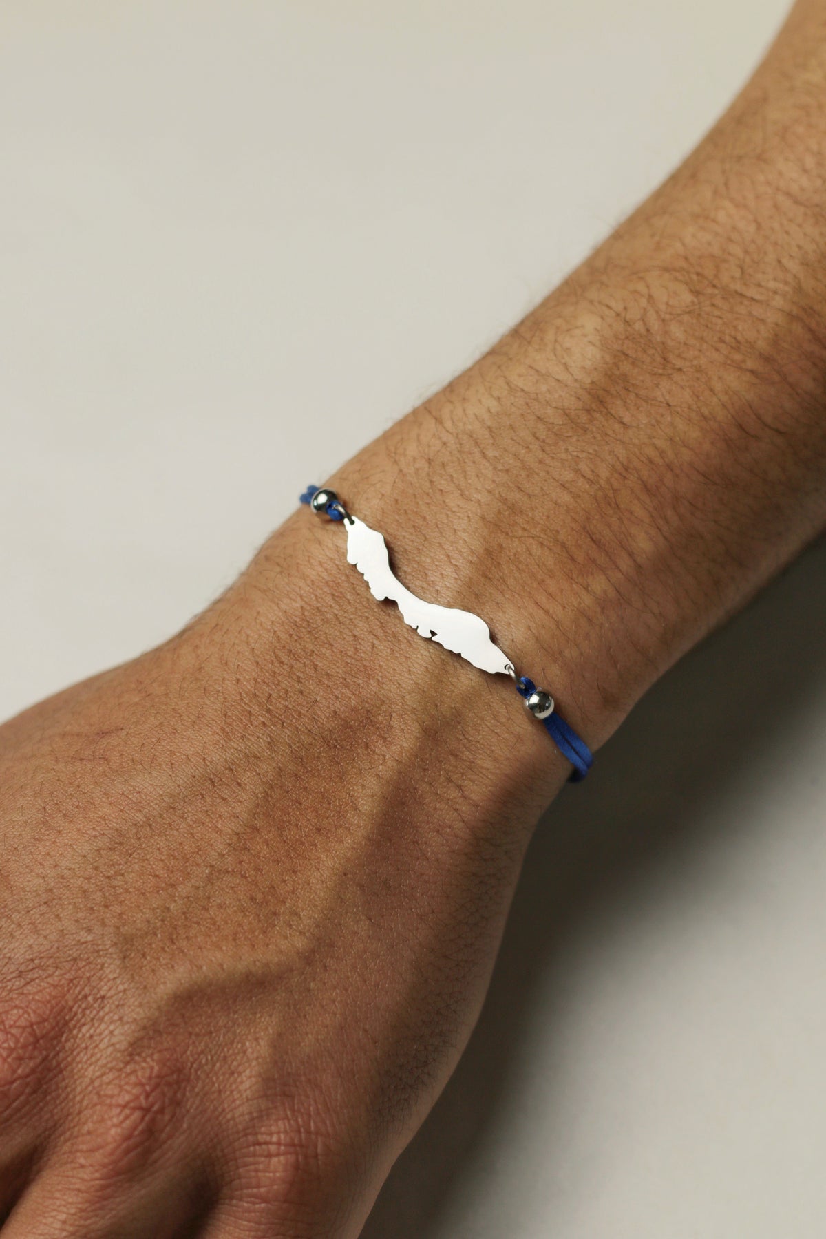 Vibrant blue men's Curaçao cord bracelet with island-shaped charm